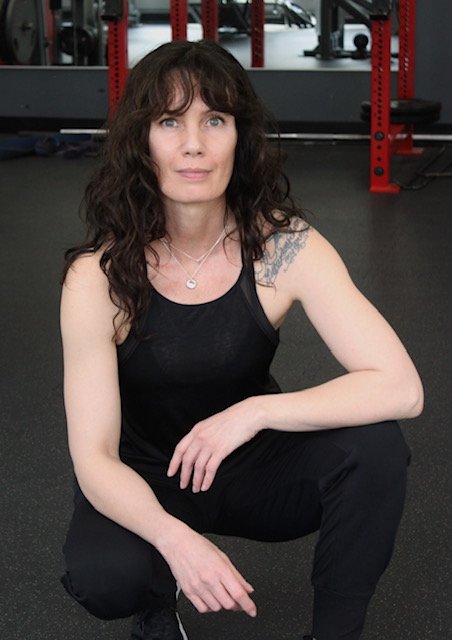 Personal trainer kneeling on the floor at Rage Fitness in Calgary Alberta