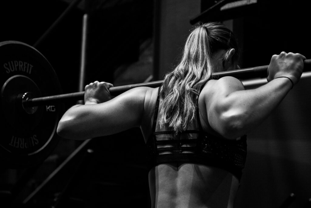 Black and white image of a woman in her 40's squatting heavy weights